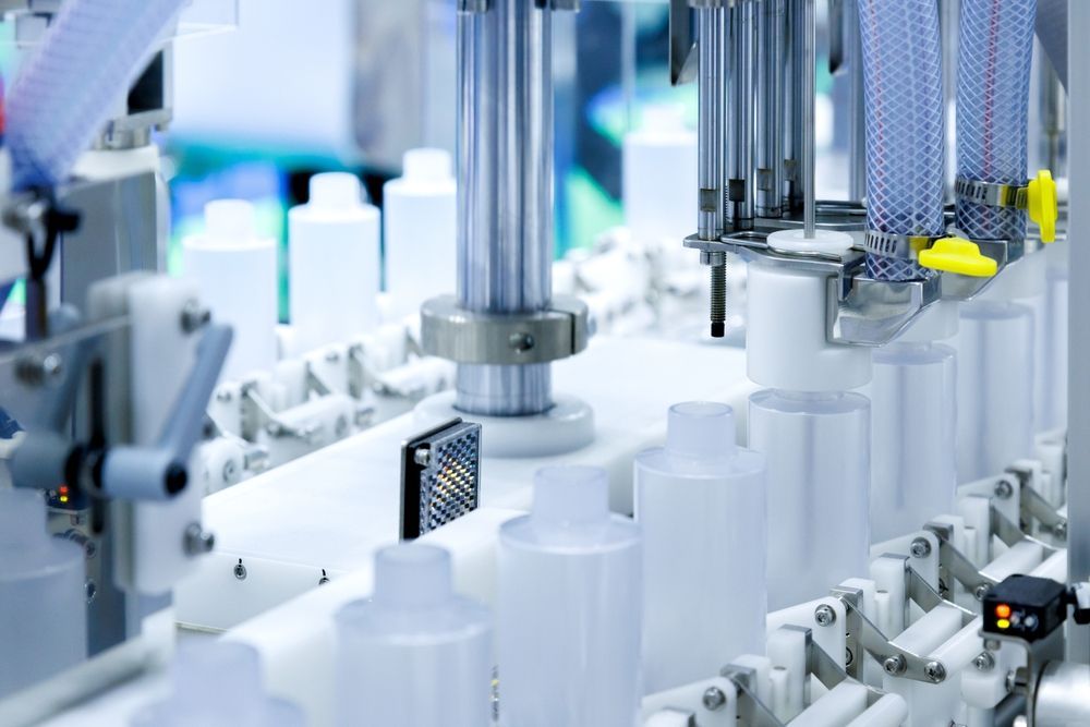 Automated Bottling Machine Filling White Plastic Bottles on a Factory Line — C & D Manufacturing In Caboolture, QLD