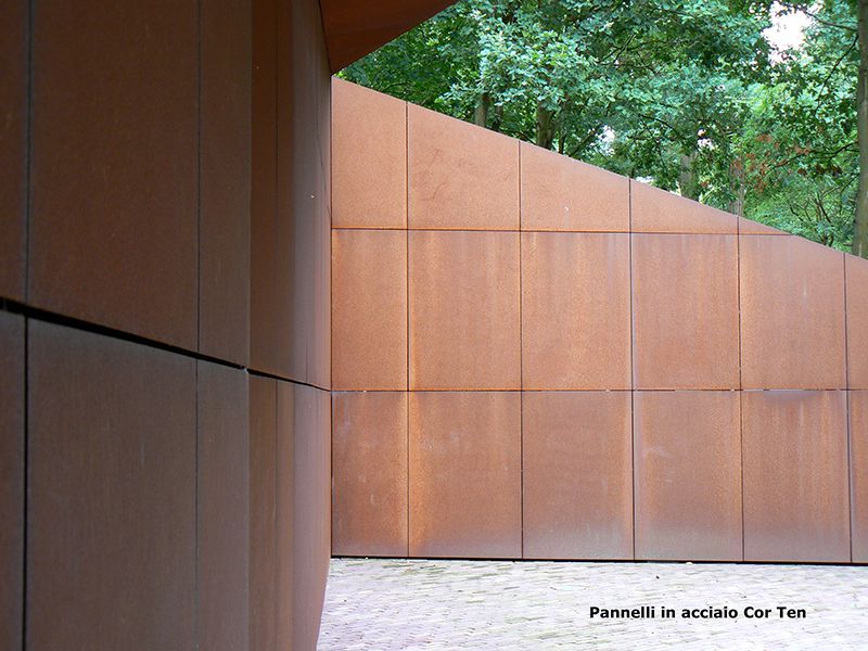 Un muro di metallo arrugginito con alberi sullo sfondo