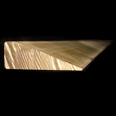 Un primo piano di un pezzo di legno su uno sfondo nero.