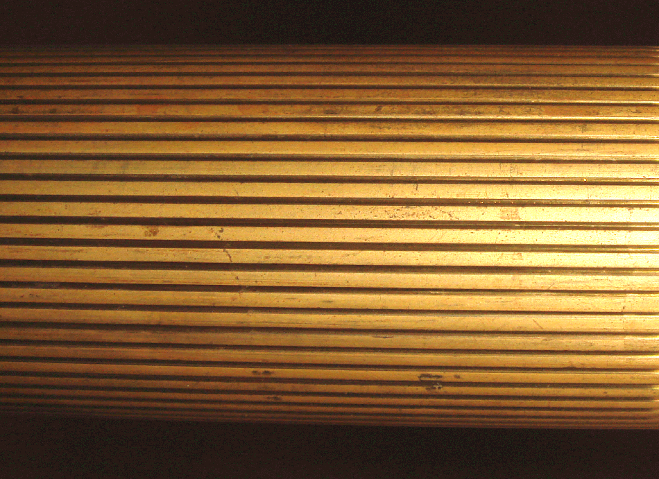 Primo piano di una superficie metallica dorata con motivo a strisce.