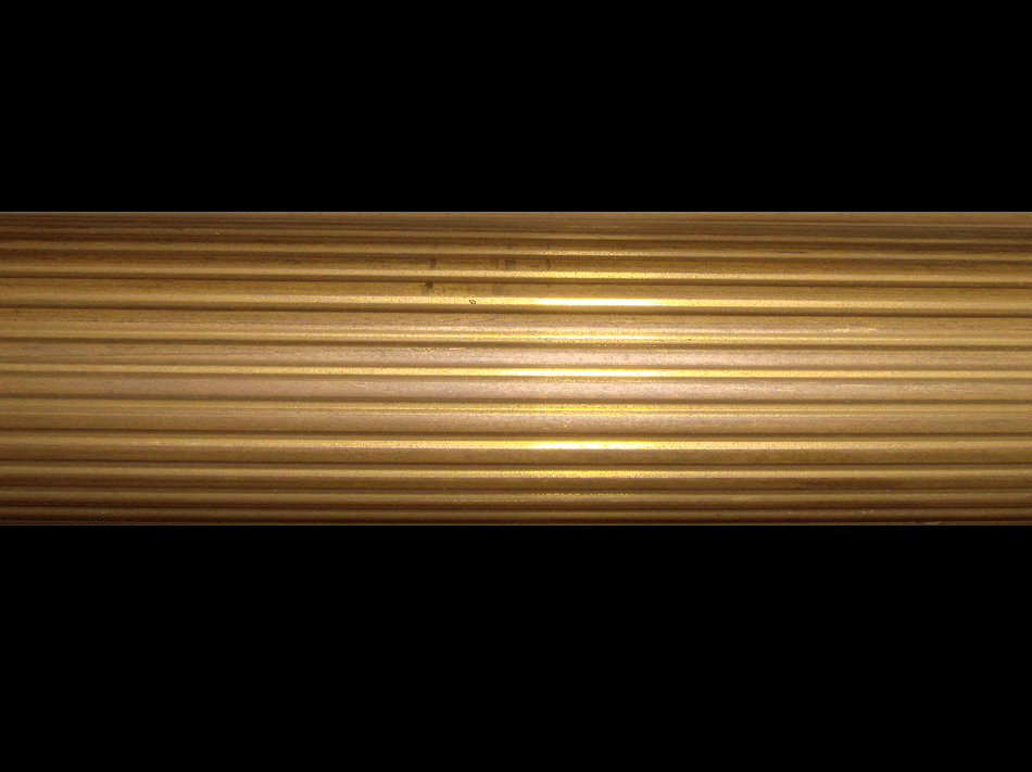 Primo piano di un tubo di metallo dorato su uno sfondo nero.