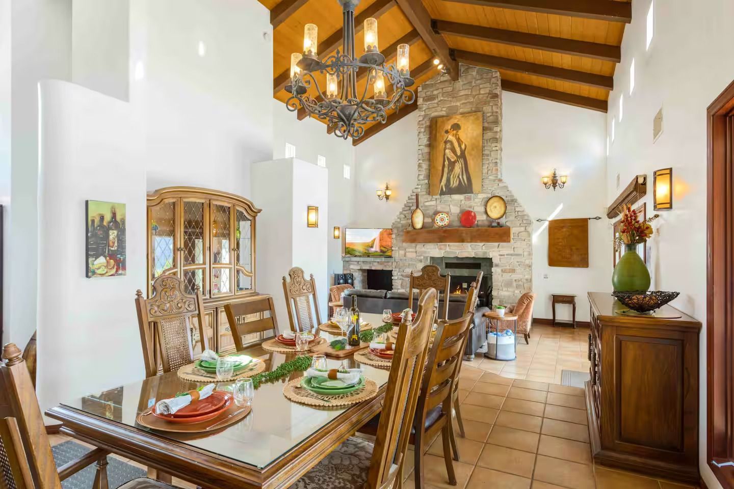 Elegant dining room with high ceilings, fireplace, and antique furniture.