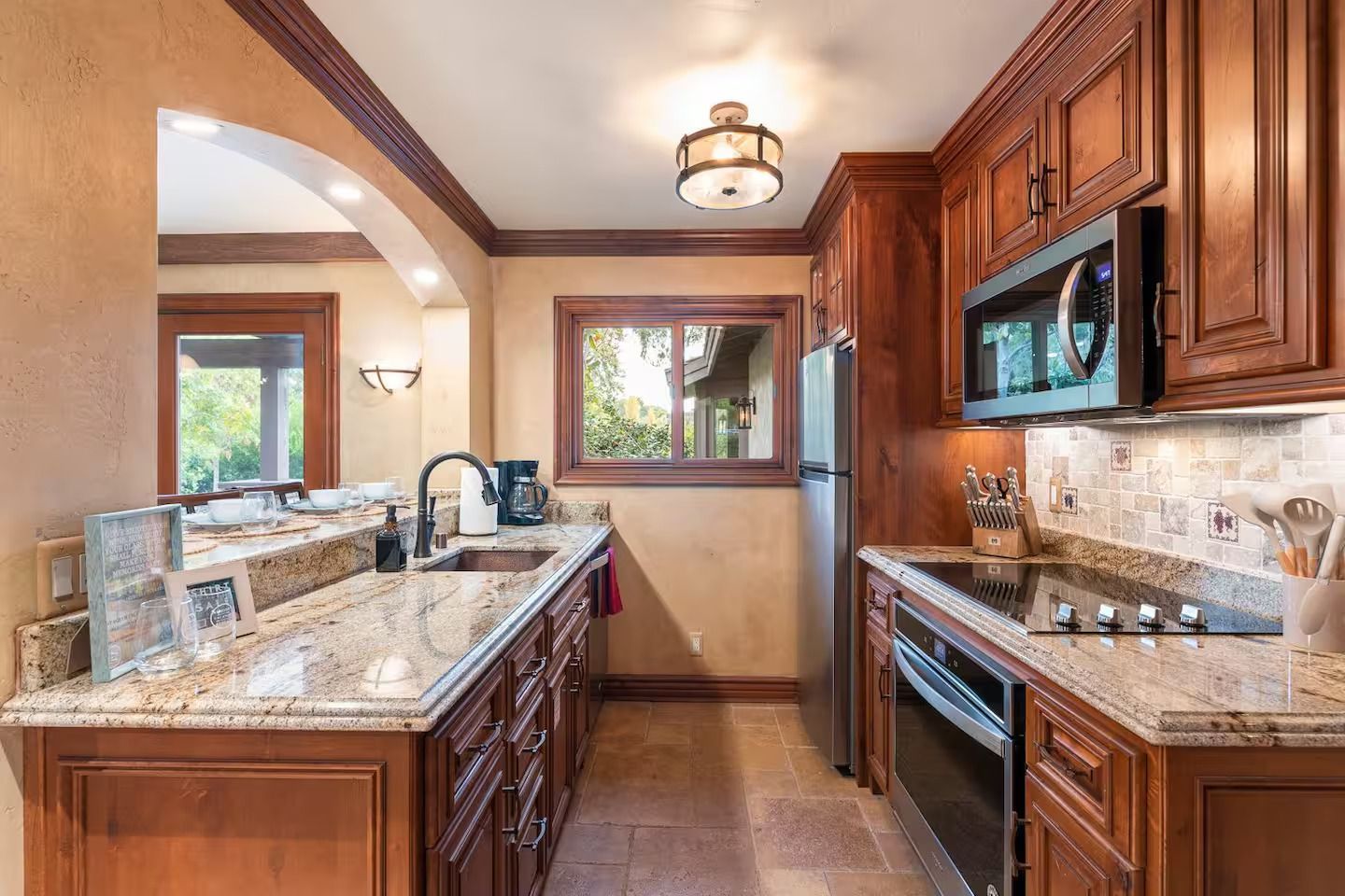 Kitchen with brown cabinets, granite countertops, and stainless steel appliances.