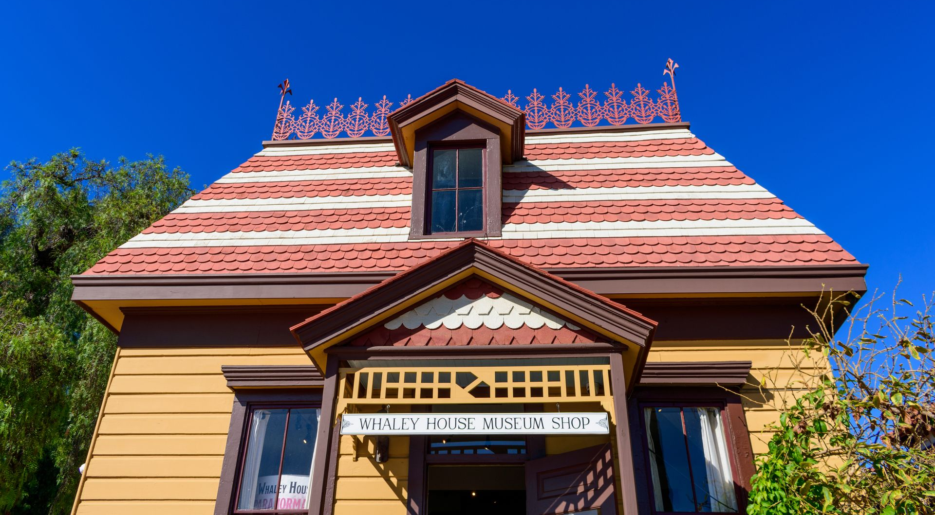 Colorful temple facade with ornate red roof, golden trim, and blue sky above
