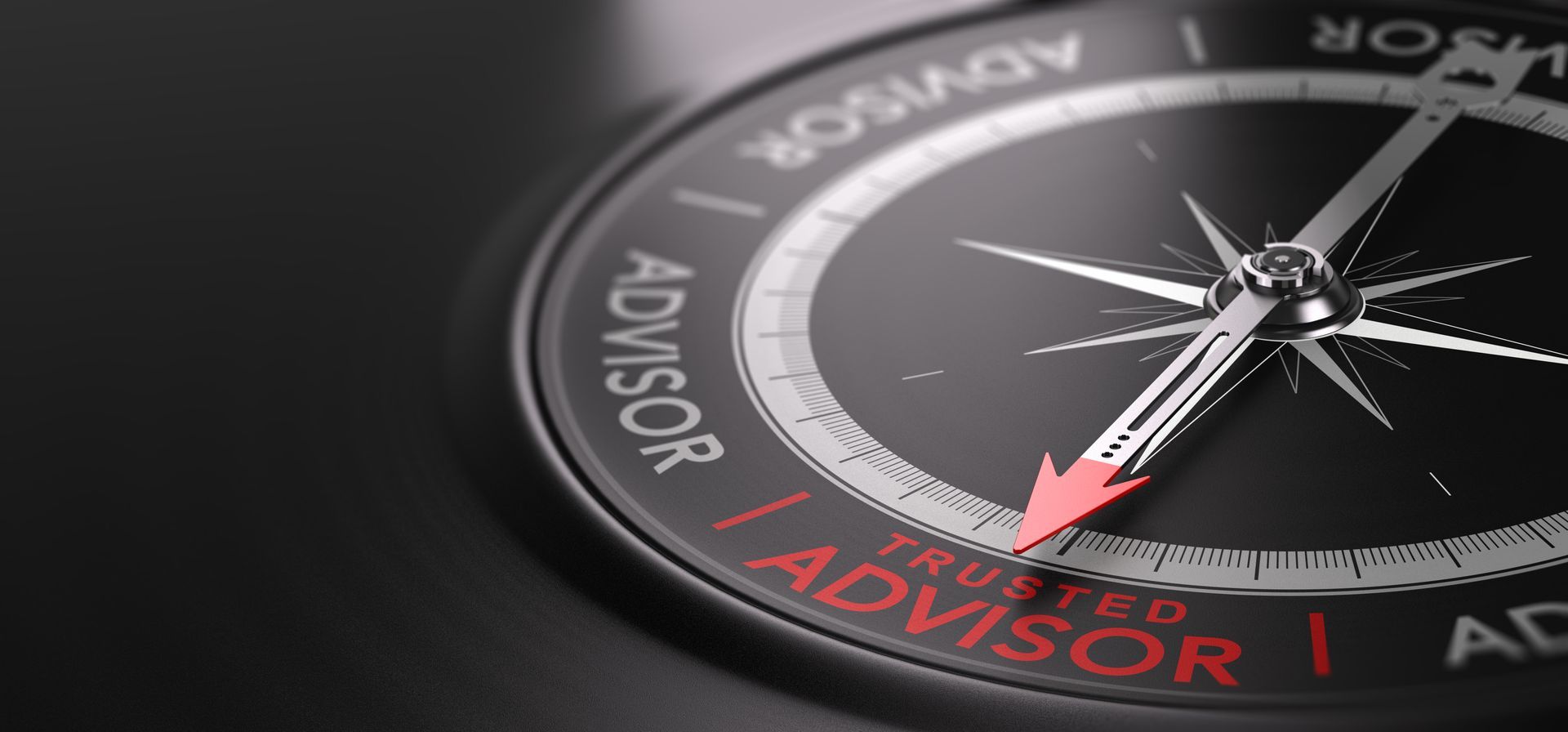 Close-up of a compass needle pointing to red “ADVISOR” text on a dark dial.