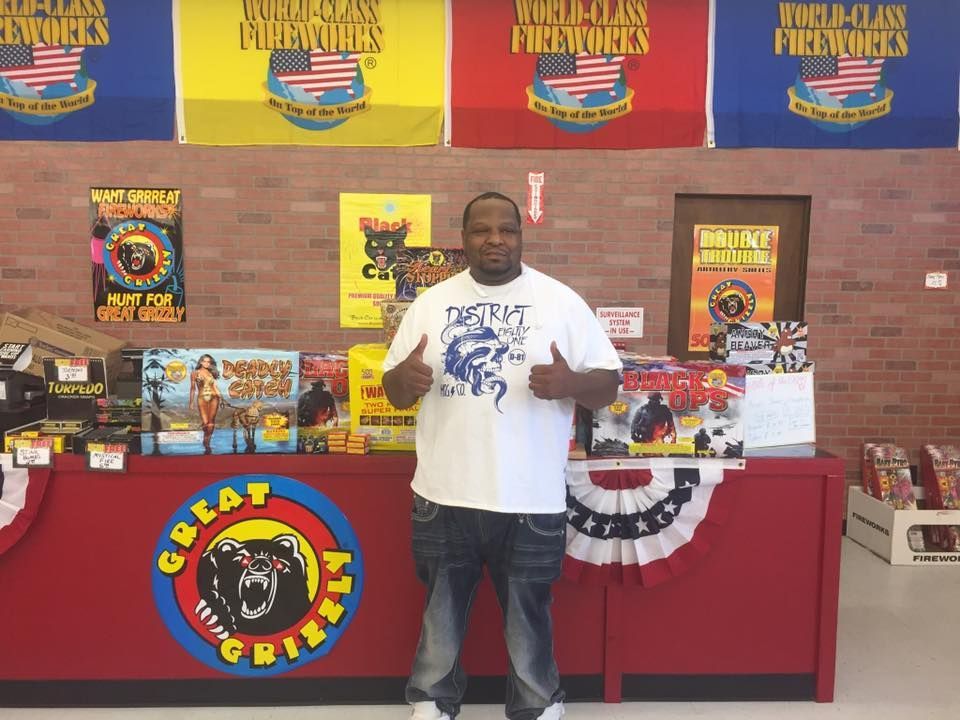 A man is standing in front of a table that says great american fireworks