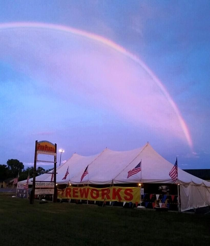 A fireworks stand with a rainbow in the background