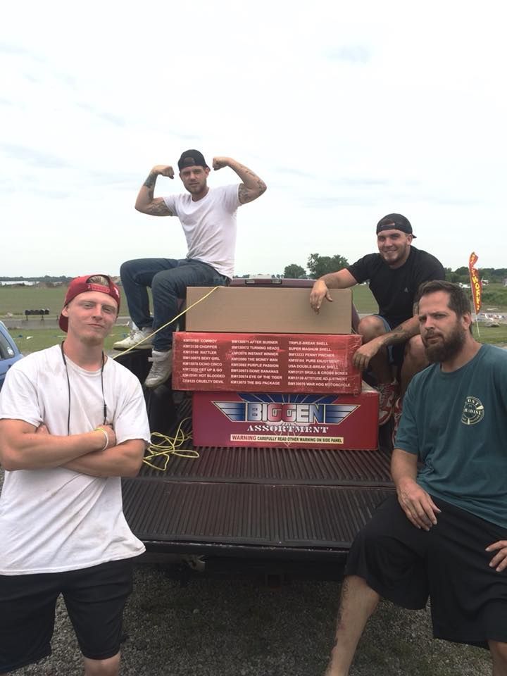A group of men are posing for a picture in the back of a truck.