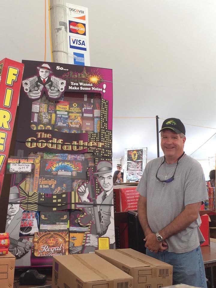 A man is standing in front of a sign that says fireworks