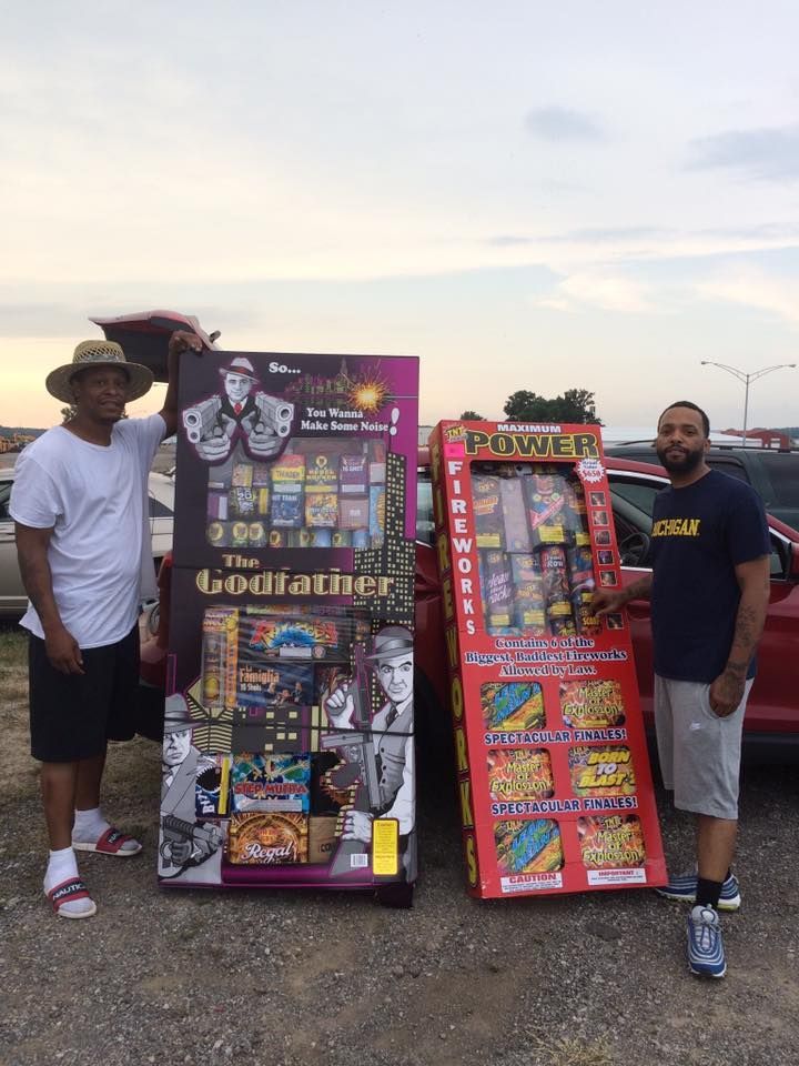 Two men are standing next to a machine that says the godfather.