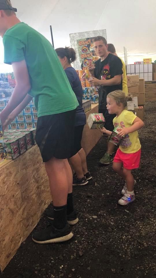 A little girl is standing next to a man in a green shirt.