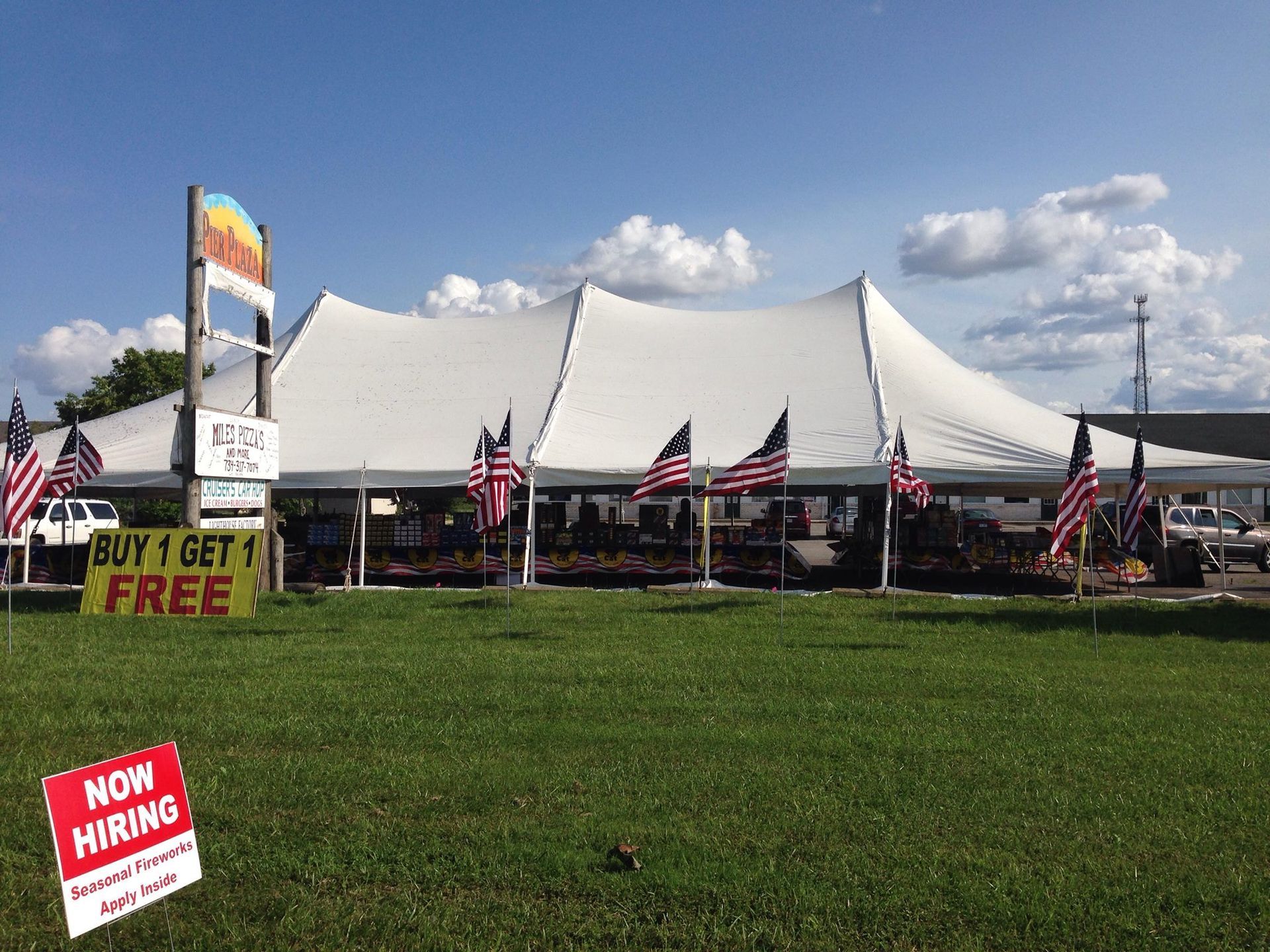 A large white tent is sitting in the middle of a grassy field.