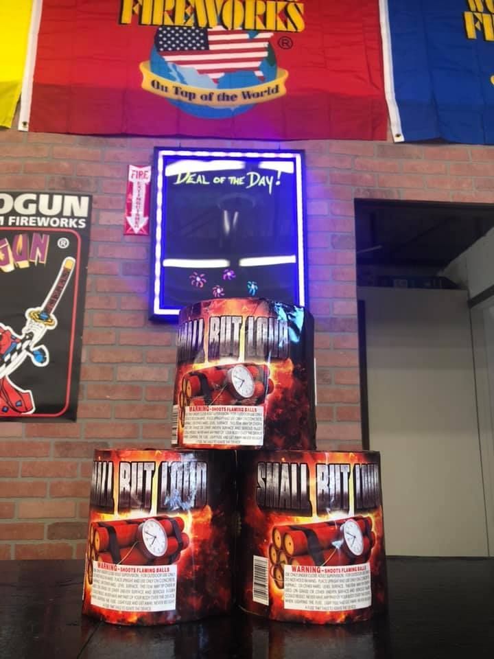 Fireworks are stacked on top of each other in front of a sign that says fireworks