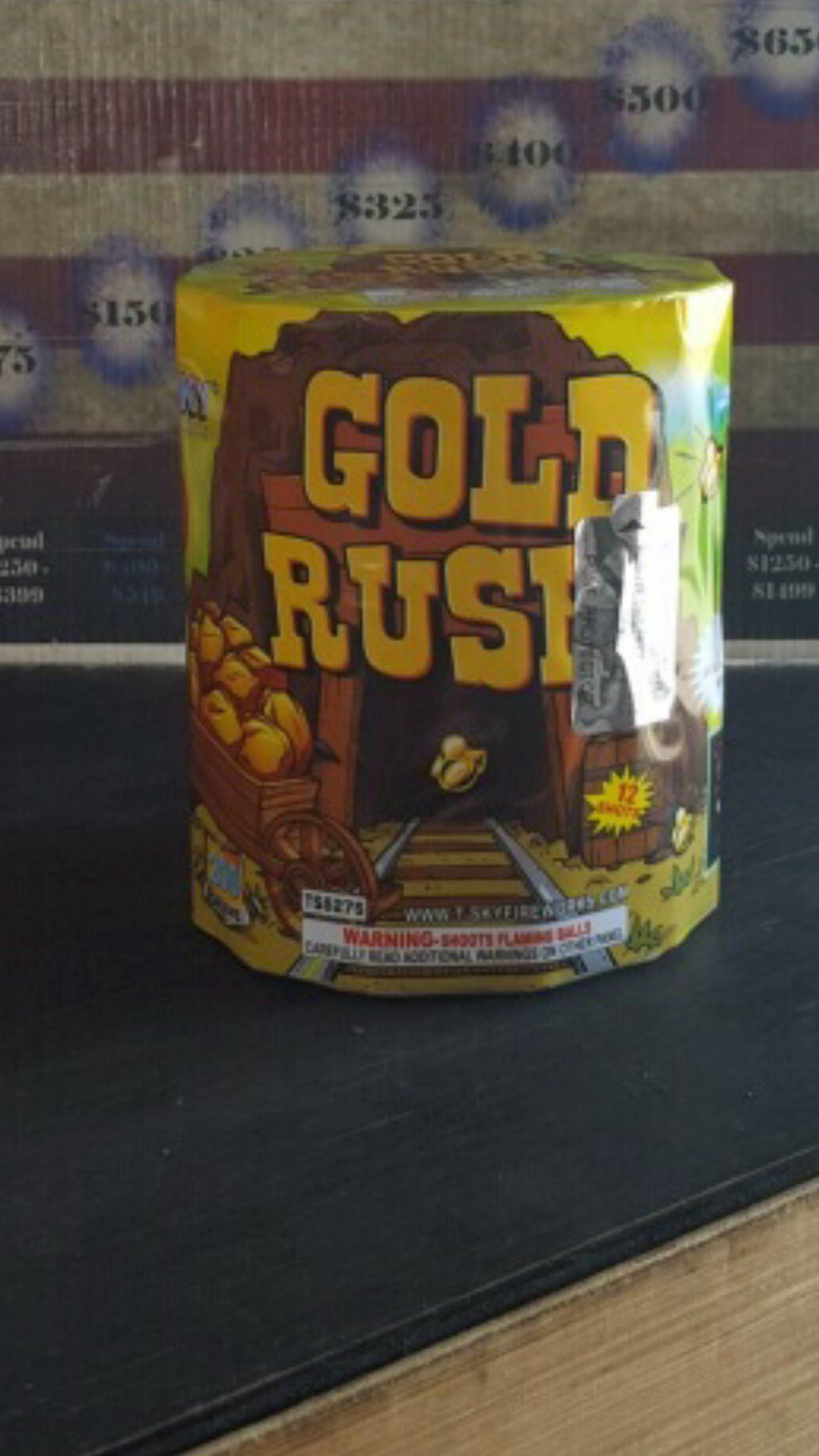 A can of gold rush fireworks is sitting on a table.