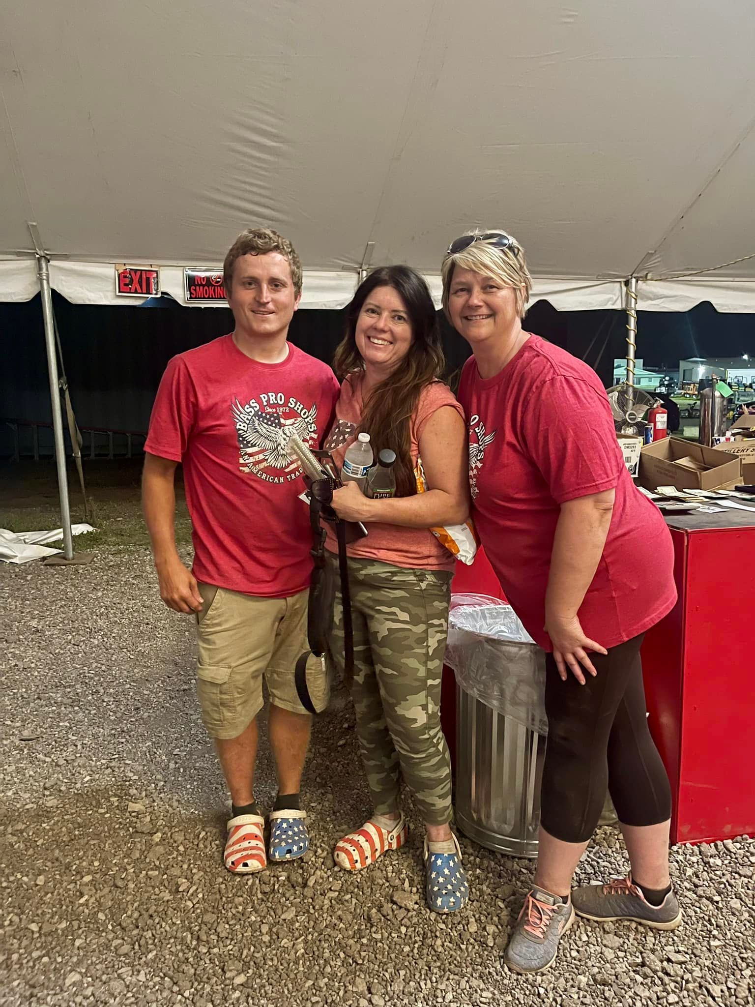 A group of people standing next to each other under a tent.