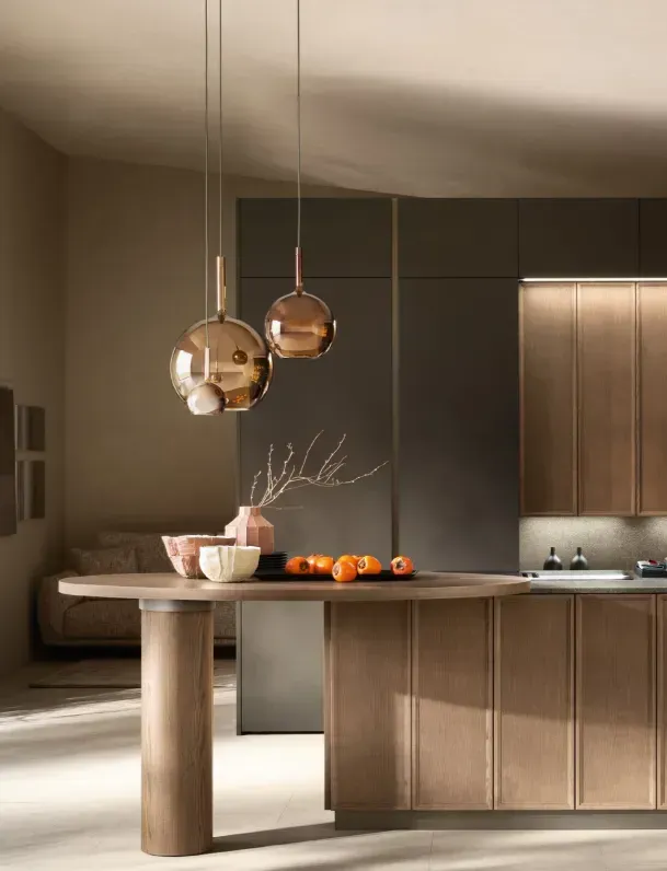Cucina moderna con mobili in legno, lampade a sospensione rotonde e un tavolo con frutta e una ciotola