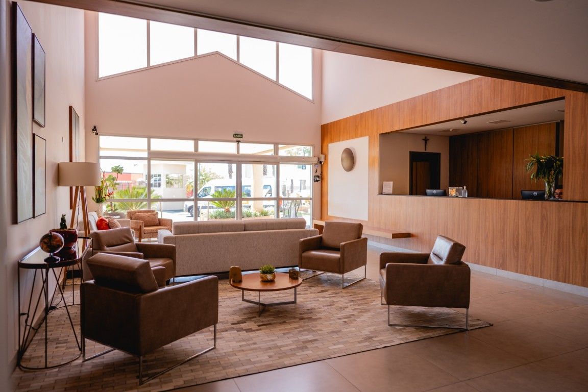 Uma sala de estar com um sofá, cadeiras e uma mesa.