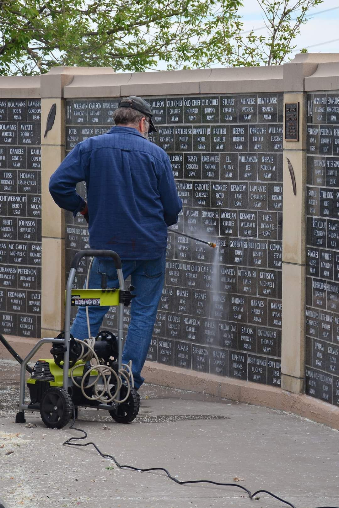 A man is cleaning a wall with a pressure washer