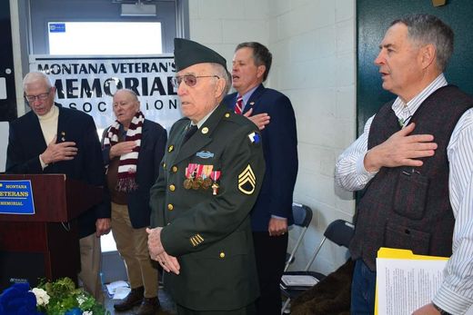 A group of men are standing in front of a sign that says montana veterans memorial