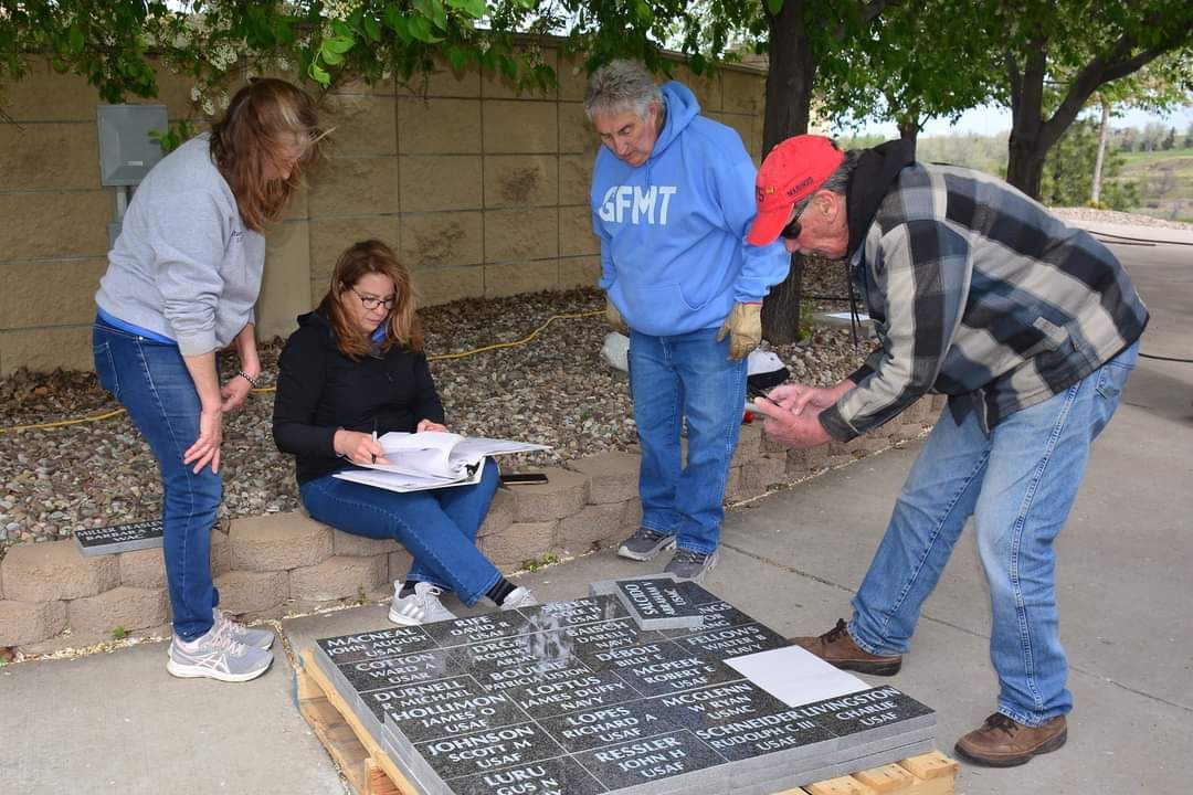 A group of people are looking at a piece of paper on the ground.