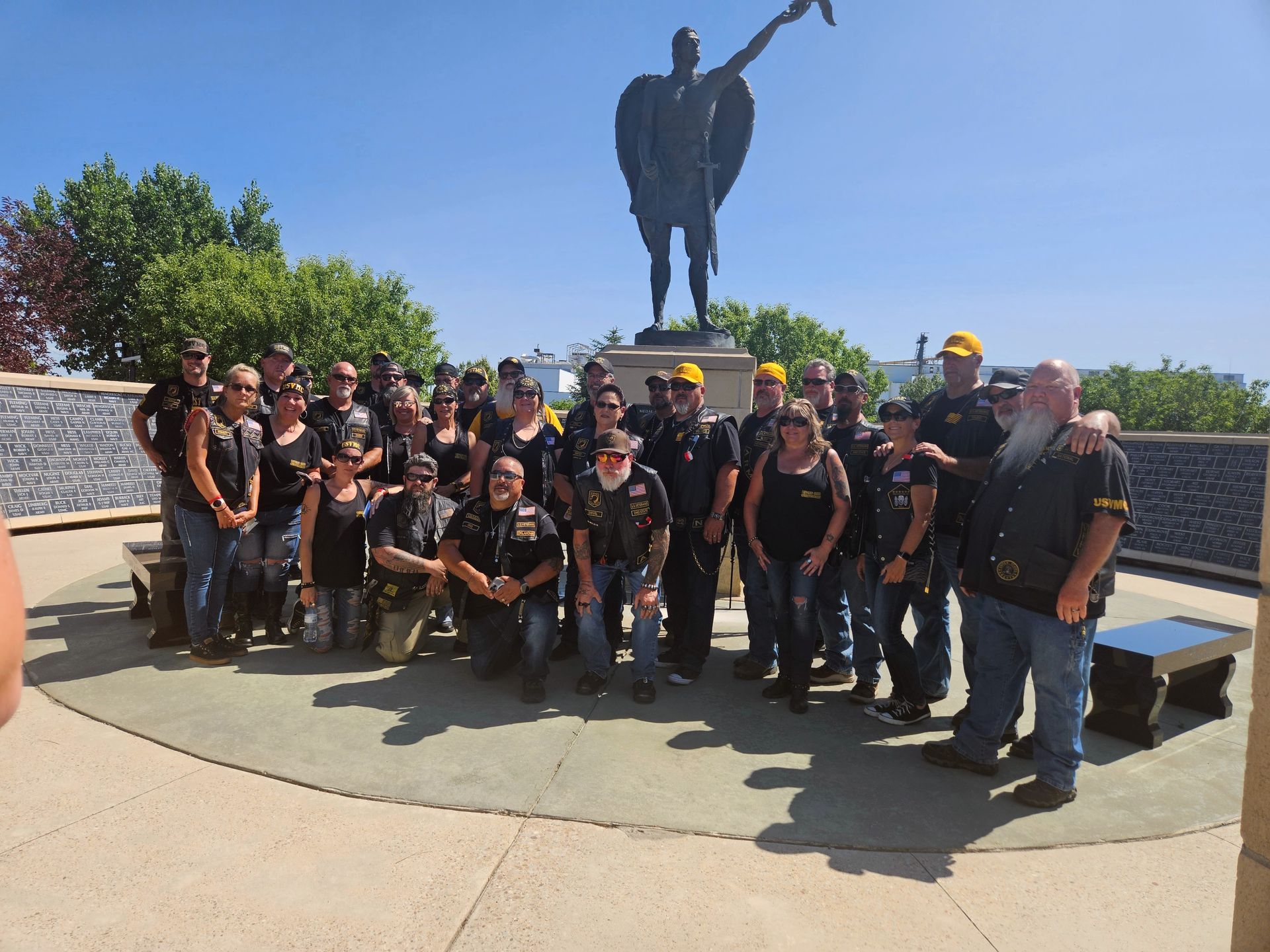 A group of people posing for a picture in front of a statue