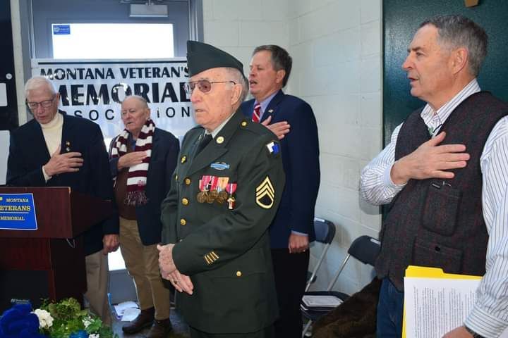 A man in a military uniform is standing in front of a podium