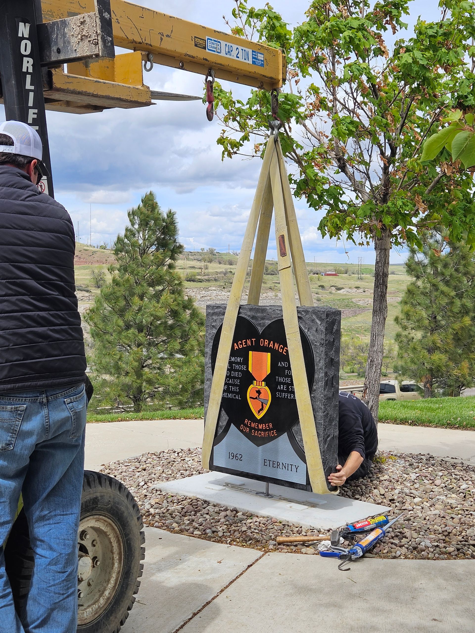 A man is lifting a statue with a medal on it
