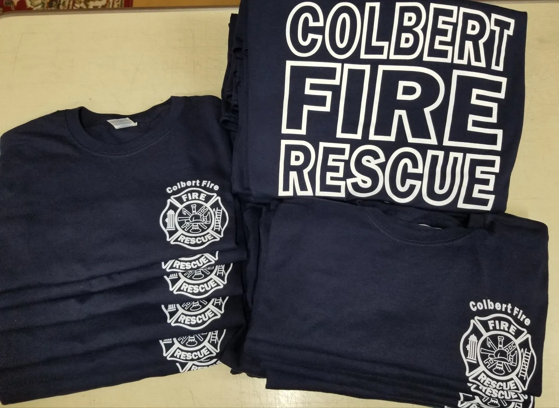 Navy blue Colbert Fire Rescue t-shirts, stacked, with white text and logo.