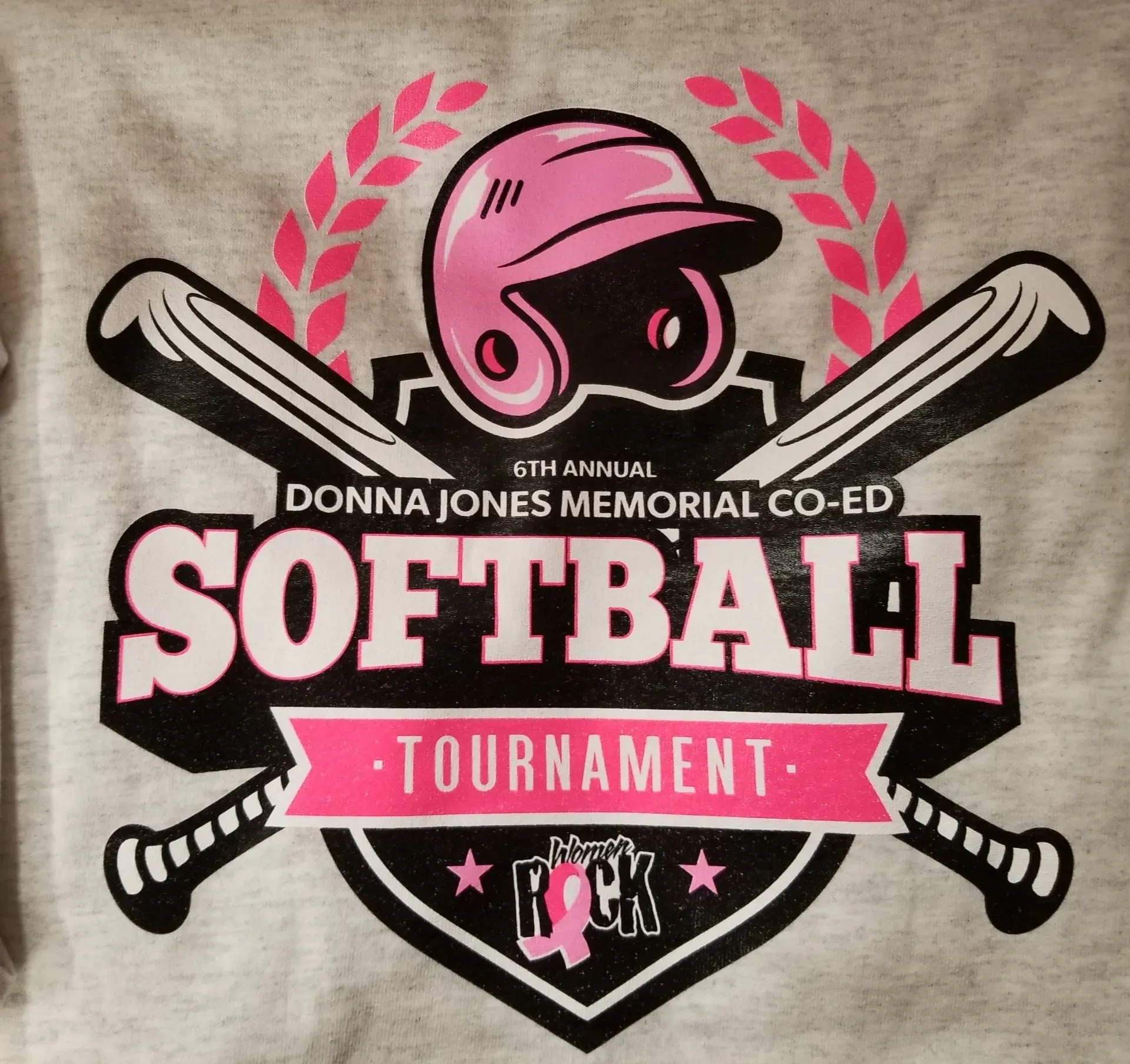 Softball tournament logo: Pink helmet, bats, and accents on gray shirt.