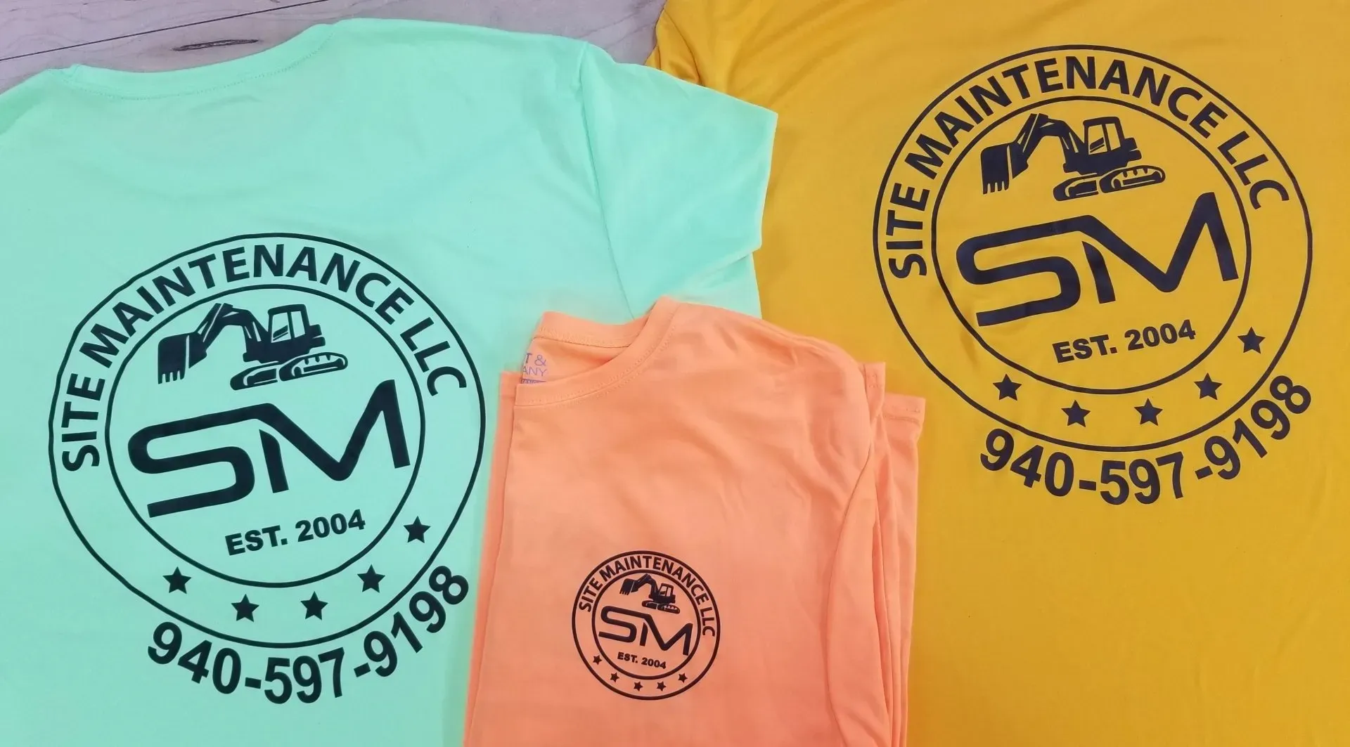 Three t-shirts, green, orange, and yellow, with a circular