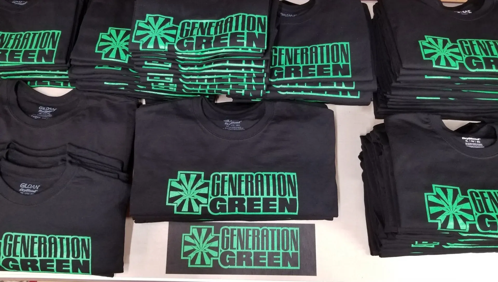 Stacks of black t-shirts with green