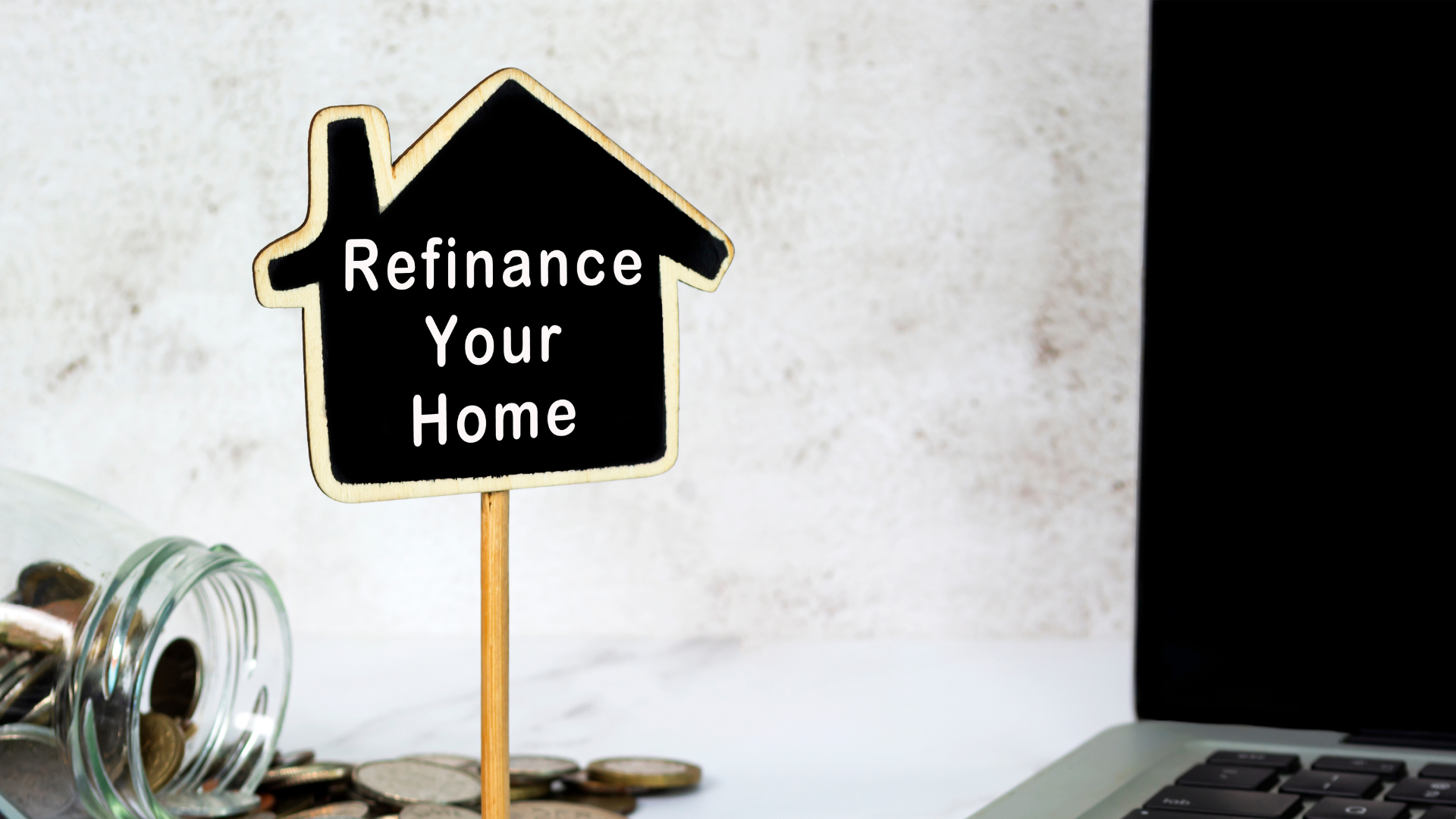 A sign in the shape of a house says `` refinance your home ''.