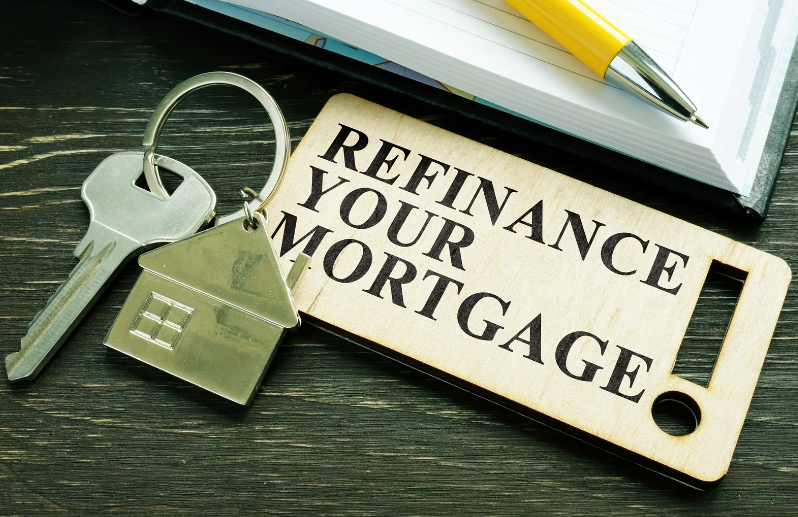 A wooden keychain with the words refinance your mortgage written on it.
