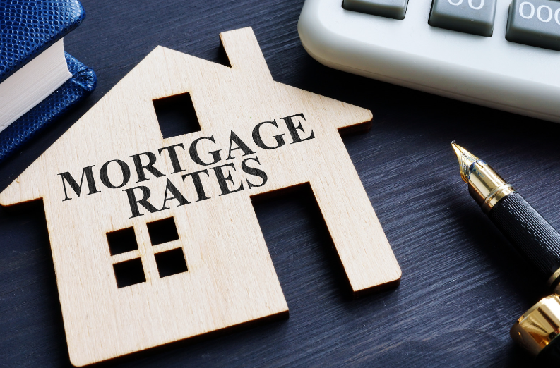 A wooden house with the words `` mortgage rates '' written on it