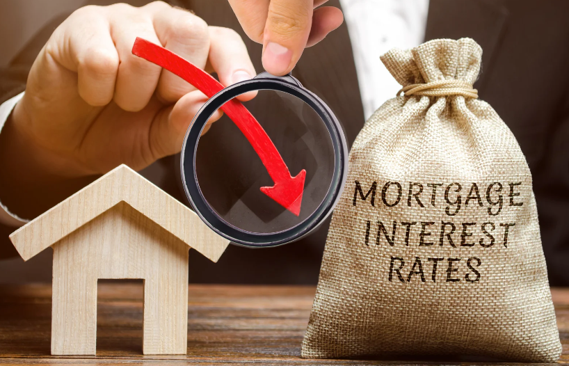 A person is looking through a magnifying glass at a house and a bag of mortgage interest rates.