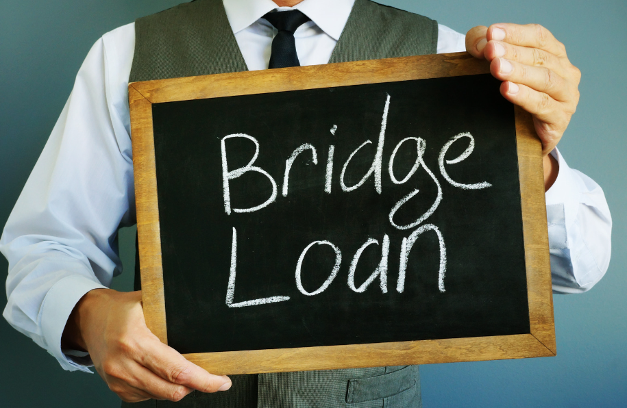 A man is holding a sign that says bridge loan