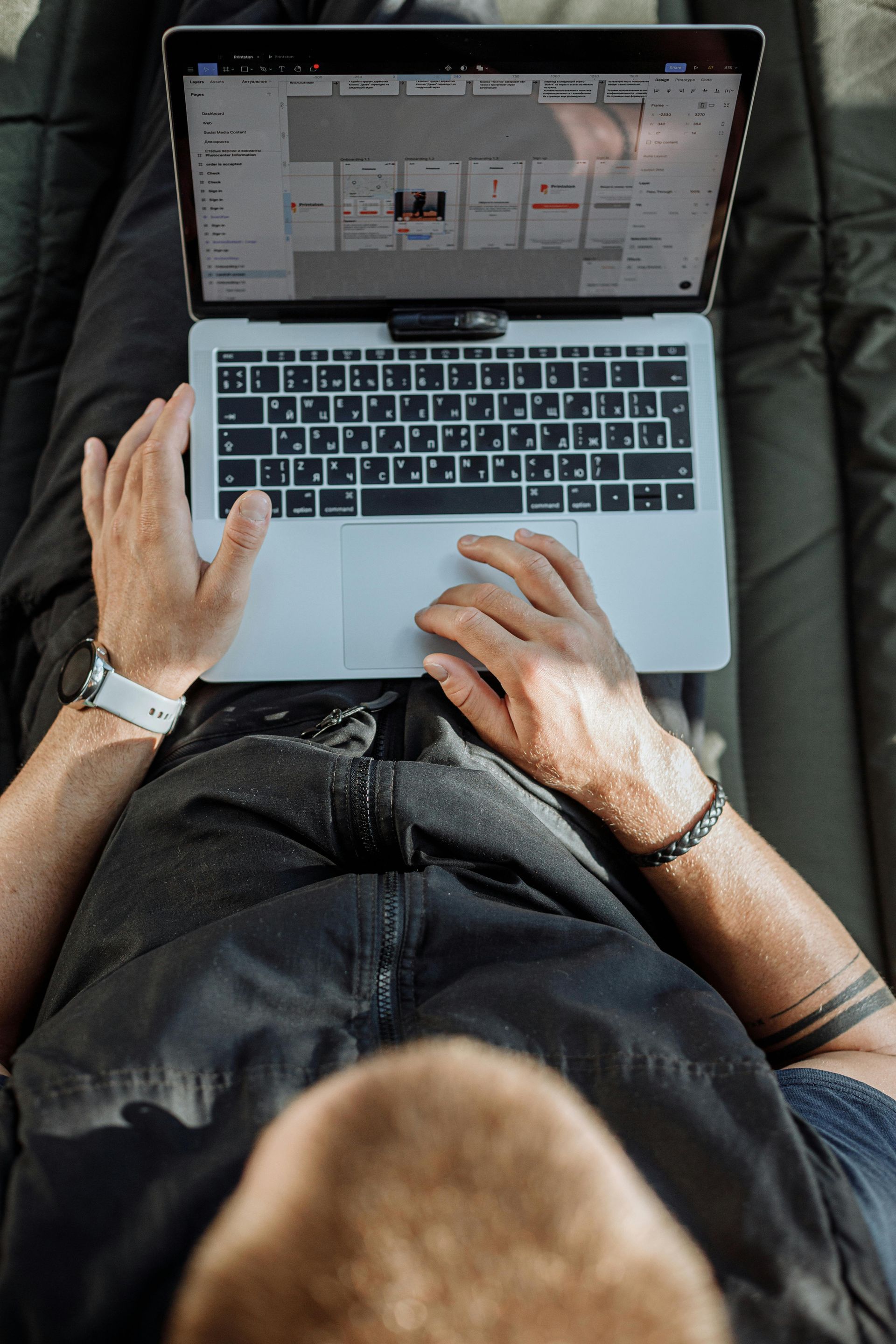 phil gustin is laying on his stomach using a laptop computer.