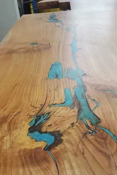 Wooden tabletop with a blue resin-filled crack running through the center