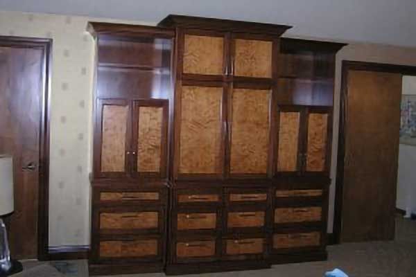 Wooden built-in cabinet with drawers and cabinets against a wall in a room