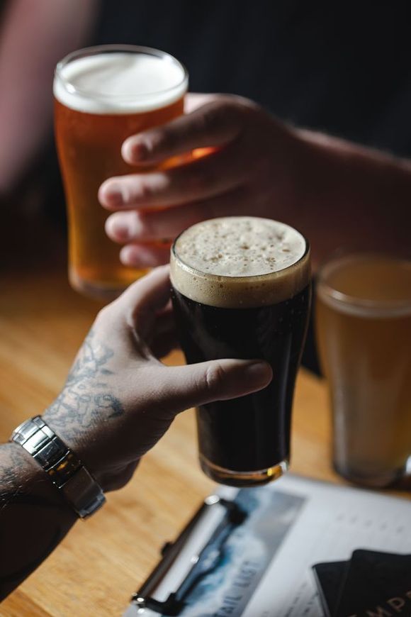 men cheering with beer in hand