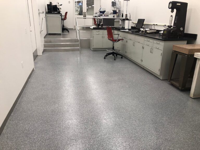 A laboratory with a gray floor and white cabinets