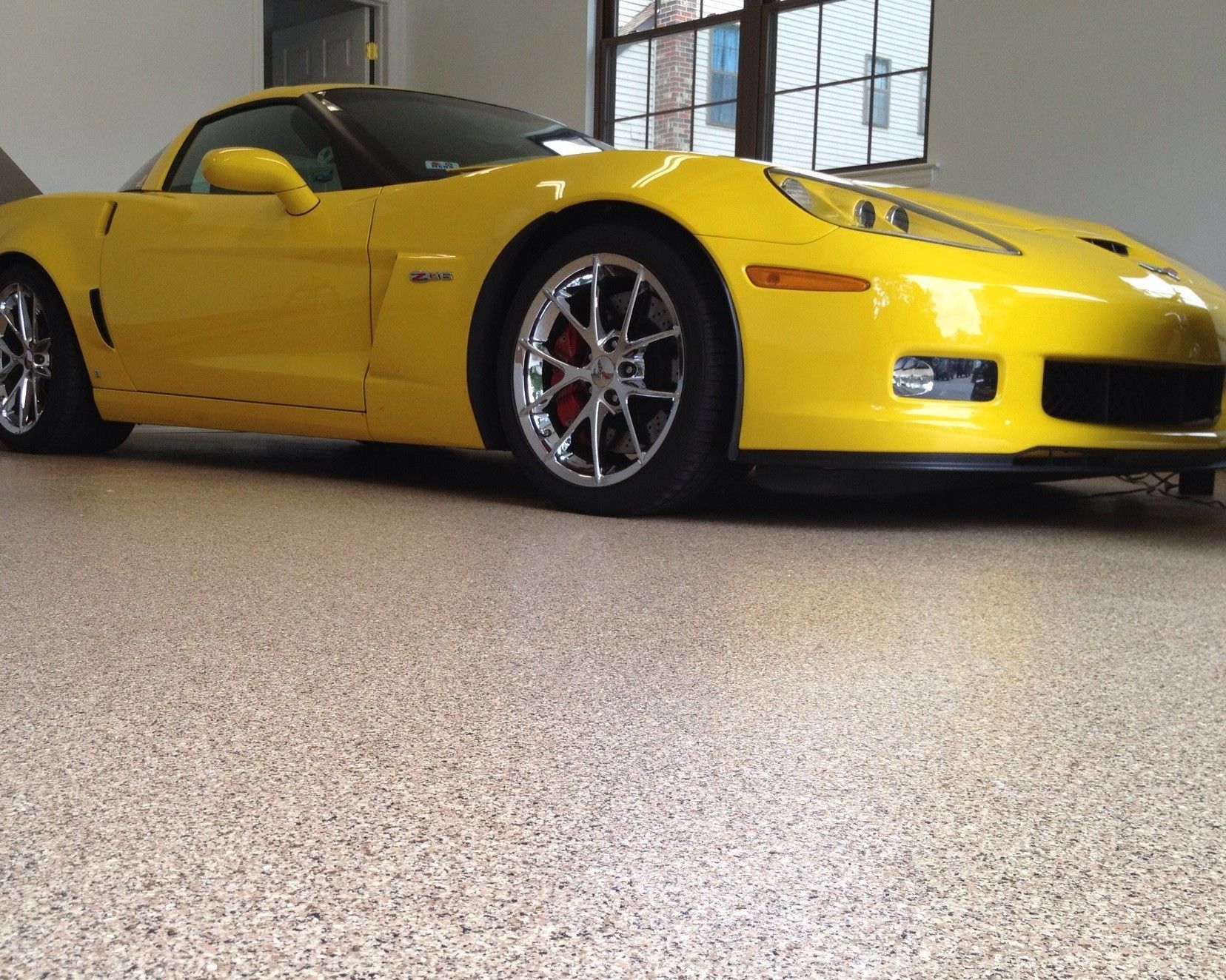 A yellow sports car is parked in a garage
