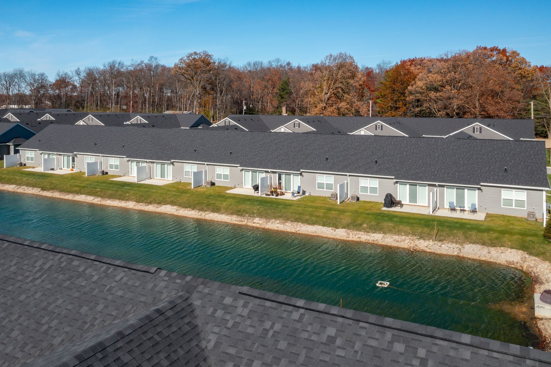 Photo of a row of homes with a small body of water in back of them,