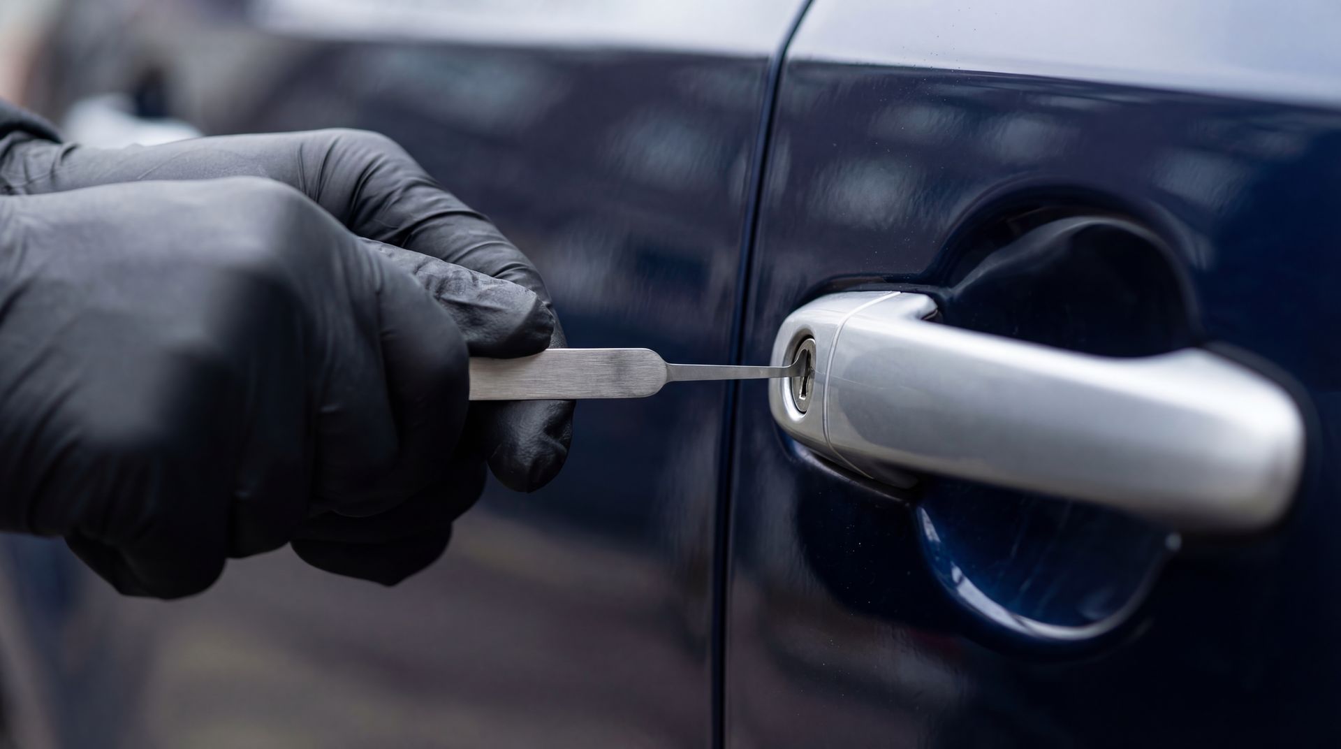Professional emergency lockout locksmith service unlocking a vehicle door handle with a tool. Professional emergency lockout locksmith service unlocking a vehicle door handle with a tool.