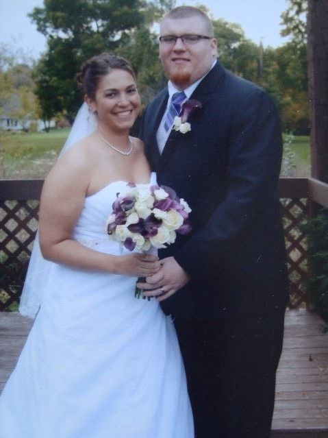 A bride and groom pose for a picture on their wedding day