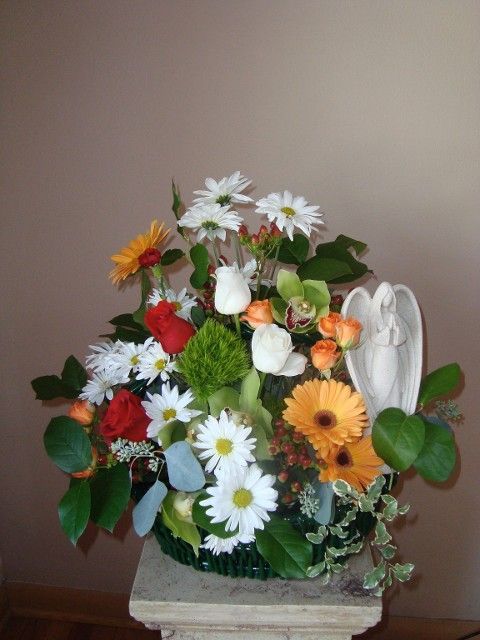 A bouquet of flowers with a statue of an angel in the middle