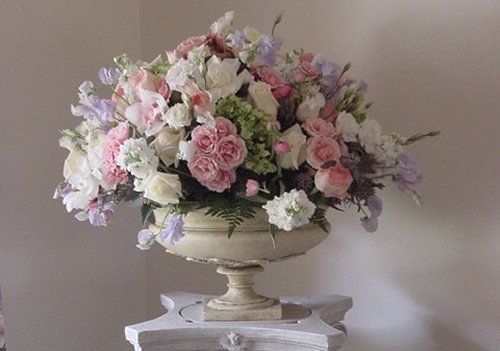 A vase filled with pink and white flowers is sitting on a table.