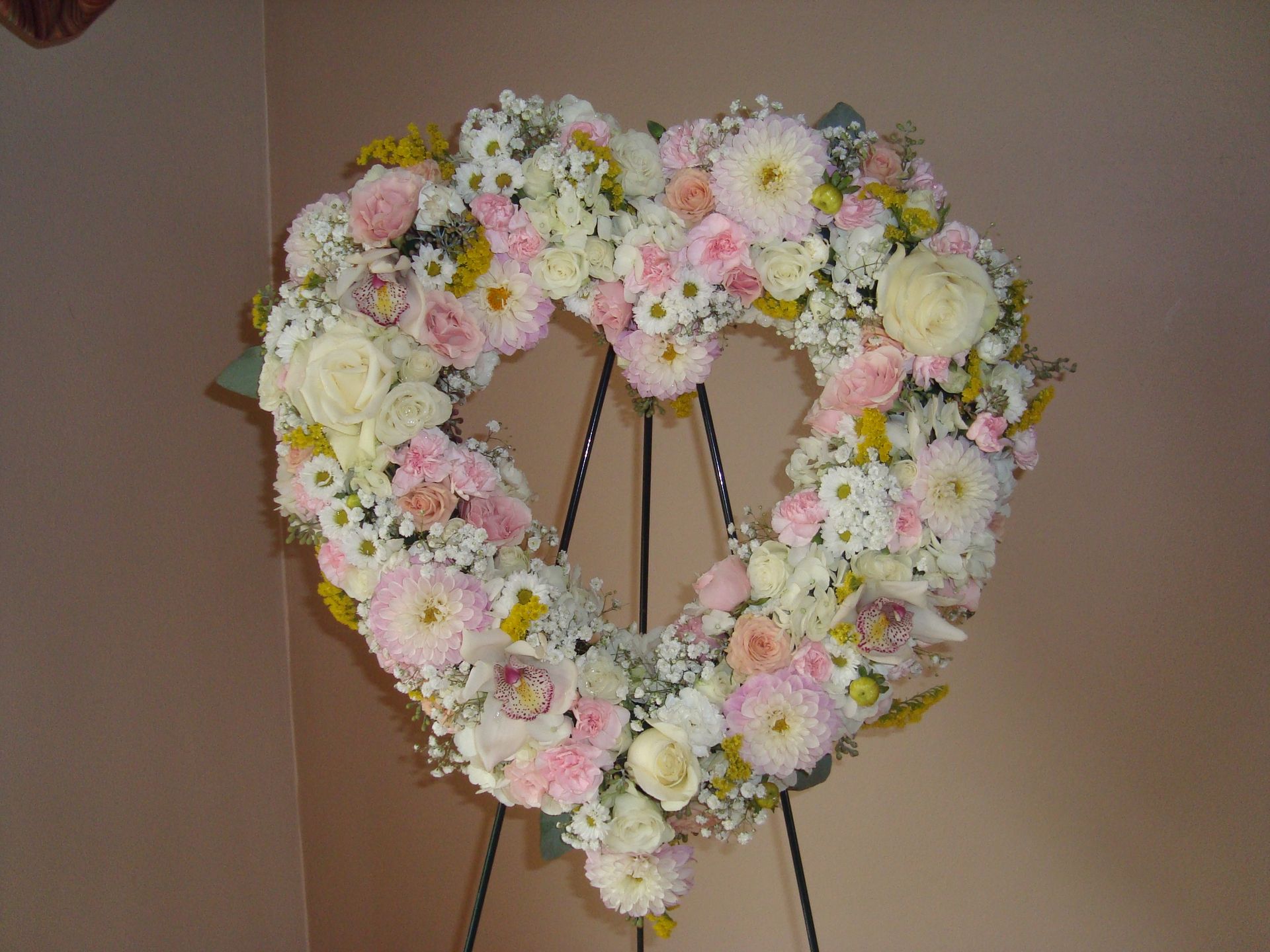 A heart shaped wreath made of pink and white flowers