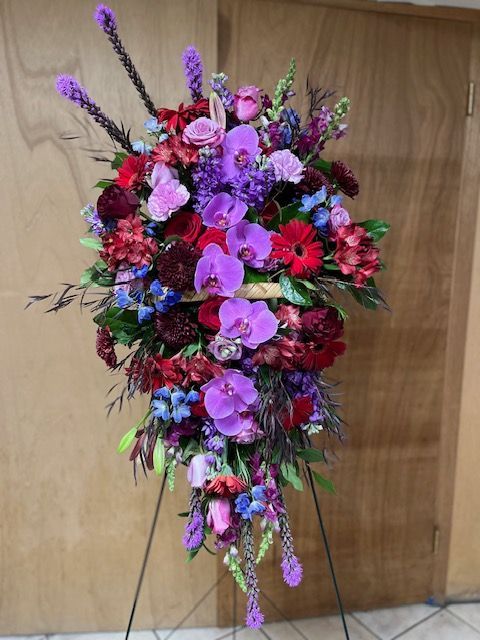 A display of purple and red flowers on a stand