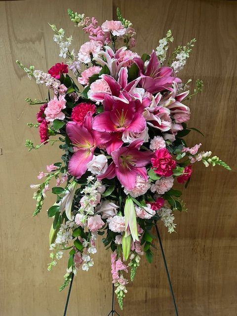 A display of pink and white flowers on a stand